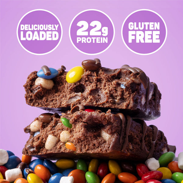 Fit Crunch bars stacked beside workout gear, ideal for athletes who need high protein snacks.