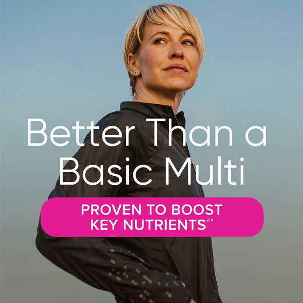 A woman smiling while taking VitaBoost Womens Ultra Mega Multivitamin, representing wellness and vitality.